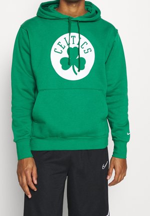 Hoodie vert avec un motif rond blanc représentant un trèfle et le texte "CELTICS" au-dessus. Fabriqué en matériau doux, il possède une poche avant et des cordons de serrage.