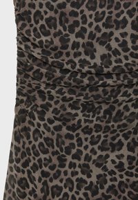 Gros plan sur un tissu à texture froncée avec un motif léopard marron foncé et noir sur fond gris.