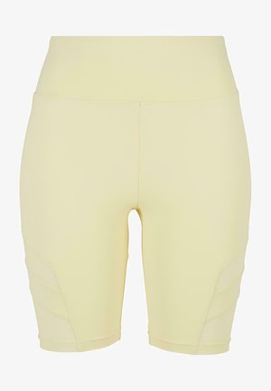 Pantalones cortos deportivos de color amarillo claro con una cinturilla alta, que presentan una textura suave y acentos de malla lateral para una mejor ventilación.