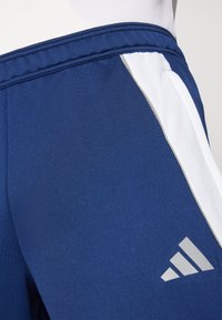 Marineblaue Sportshorts mit weißen Seitenpaneelen, gefertigt aus strukturiertem Stoff. Mit grauem Logoakzent unten rechts und elastischem Bund.