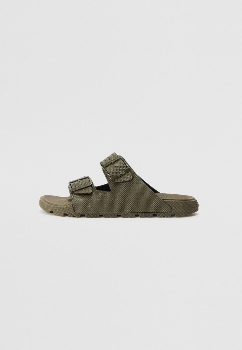 Πράσινα σανδάλια με δύο ρυθμιζόμενες αγκράφες, υφή στην επάνω επιφάνεια και ανατομική σόλα. Διαθέτουν χοντρή ελαστική σόλα με πρόσφυση.