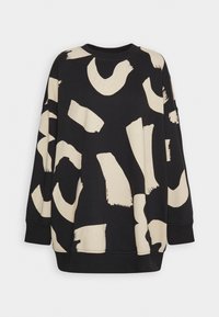 Sweat-shirt noir à manches longues avec de grands motifs irréguliers beige en coups de pinceau dispersés sur le tissu.