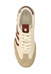 Sneaker beige con strisce in pelle marrone e punta in suede. Presenta lacci bianchi, un logo rotondo argentato e un interno imbottito.