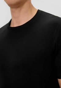 Schwarzes Baumwoll-T-Shirt mit Rundhalsausschnitt und kurzen Ärmeln. Der Stoff hat eine glatte Textur und eine figurbetonte Silhouette.