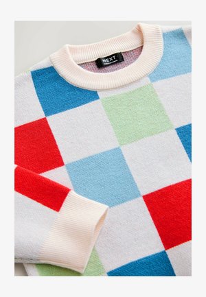 Kolorowy, oversize'owy sweter z wzorem patchworkowym w czerwone, niebieskie, zielone i białe kwadraty. Żebrowany kremowy kołnierz i mankiety. Miękka faktura.