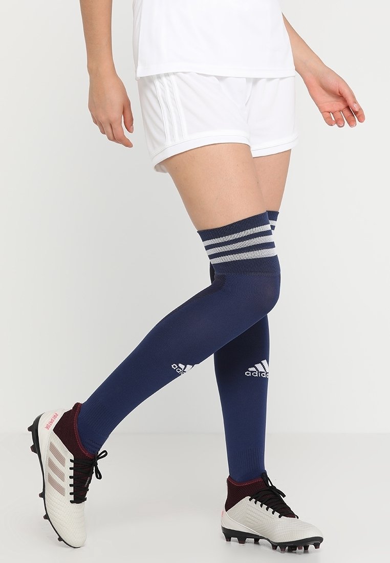 Marinblå knästrumpor med vit och grårandig resår. Tillverkade av elastiskt material och med Adidas-logotyp på framsidan.