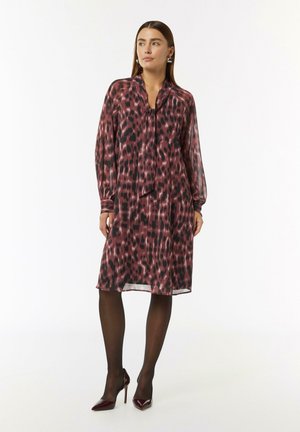 Langes, fließendes Kleid in tiefem Pink und schwarzem Tierdruck. Verfügt über einen weichen Kragen, lange Ärmel und eine subtile Schleife am Halsauschnitt.