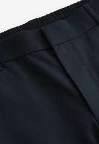 Schwarzer gewebter Stoffbund der Hose mit glatter Oberfläche, verfügt über ein flaches Frontdesign und keine sichtbaren Beschläge oder Akzente.
