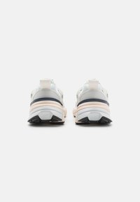 Light gray and white sneakers with a thick sole, textured mesh upper, padded collar, and a rubber outsole with black accents.