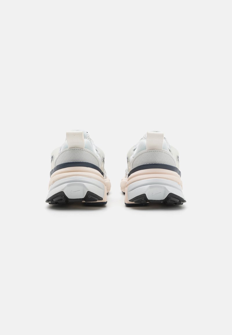 Zapatillas ligeras en gris claro y blanco con suela gruesa, upper de malla texturizada, cuello acolchado y suela de goma con detalles en negro.