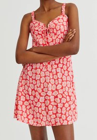 Blumenkleid in Rosa- und Rottönen, mit tailliertem Oberteil, quadratischem Ausschnitt, verstellbaren Trägern und einem Kordelzug vorne sowie einem ausgestellt Rock.