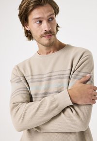 Beige gestrickter Pullover aus strukturiertem Stoff mit horizontalen Streifen in Hellblau und Grau. Rundhalsausschnitt und gerippte Bündchen.