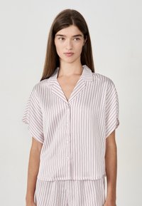 Korte mouwen, knoopsluiting pyjamahemd in lichtroze met verticaal witte en bordeauxrode strepen. Gladde, lichte stof met een ontspannen pasvorm.