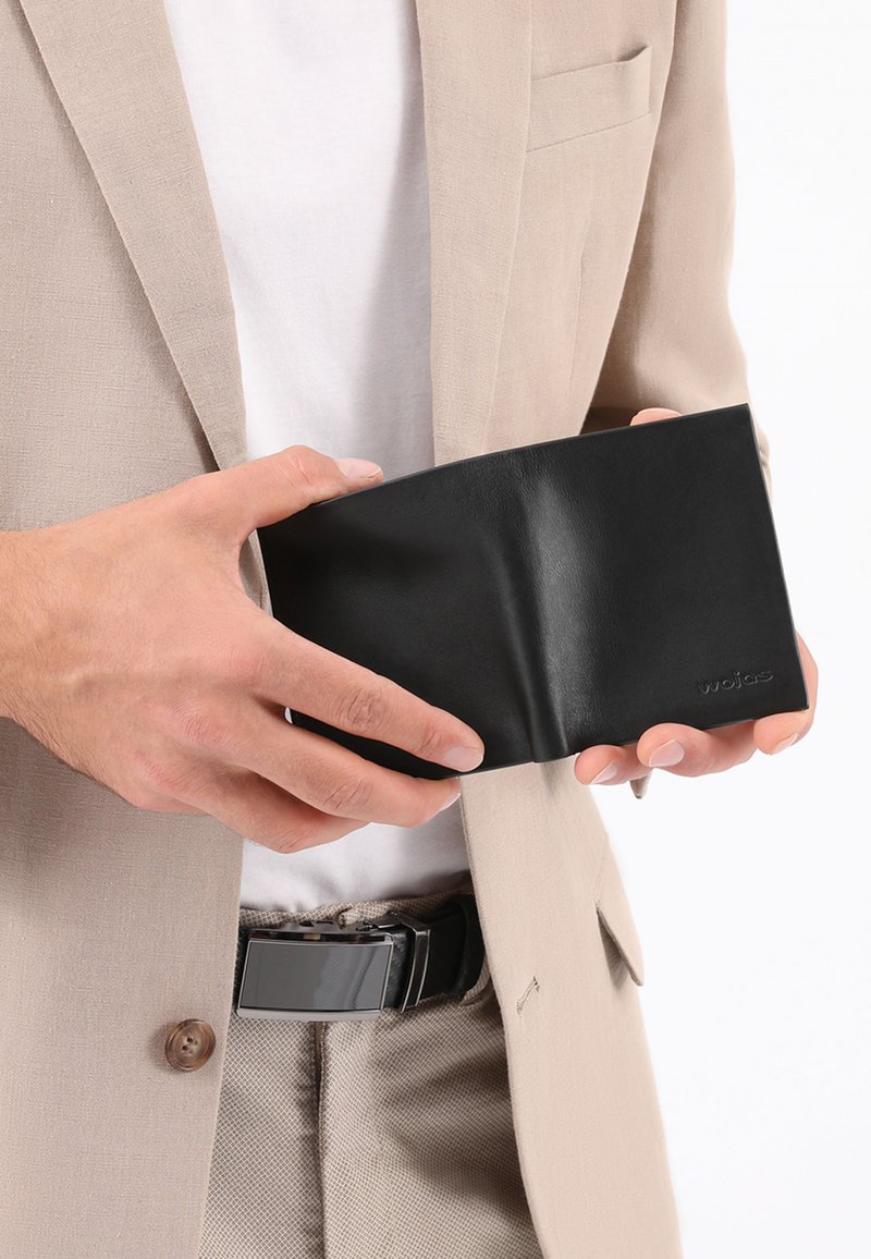 Schwarzes Lederportemonnaie in der Hand gehalten, mit glatter Oberfläche und minimalistischer Gestaltung. Prägungslogo deutlich auf der Vorderseite.
