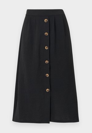 Jupe midi noire à texture lisse, avec six boutons en bronze sur le devant et une taille soulignée par une large bande.