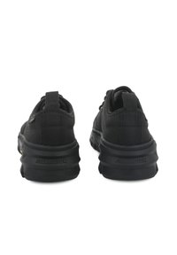 Μαύρα πάνινα παπούτσια με χοντρή λαστιχένια σόλα, με υφασμάτινο επάνω μέρος με υφή, ενισχυμένη πτέρνα και λογότυπο στο πίσω μέρος.