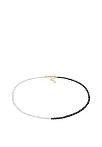 Collier de perles alternant des perles noires et blanches, avec fermoir doré et chaînette d'extension. Design élégant et minimaliste avec une texture lisse.