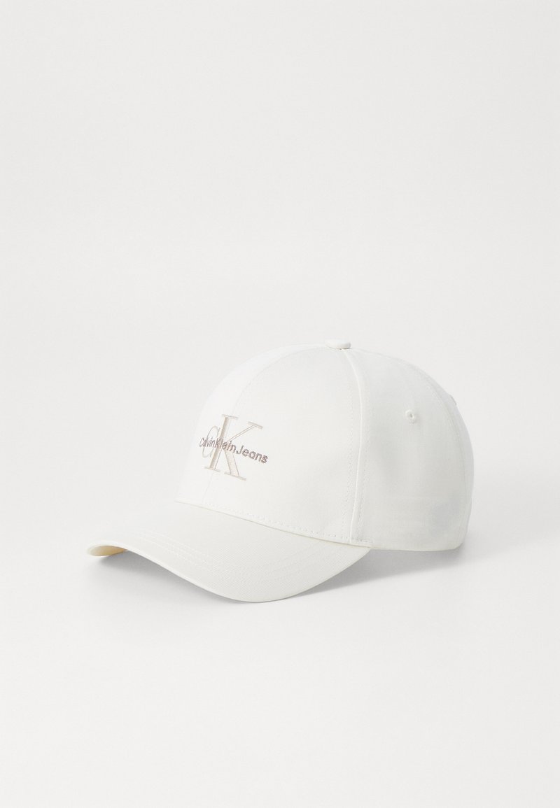 Cappello da baseball bianco realizzato in tessuto misto cotone, con un logo ricamato color marrone chiaro. Visiera curva con superficie testurizzata.