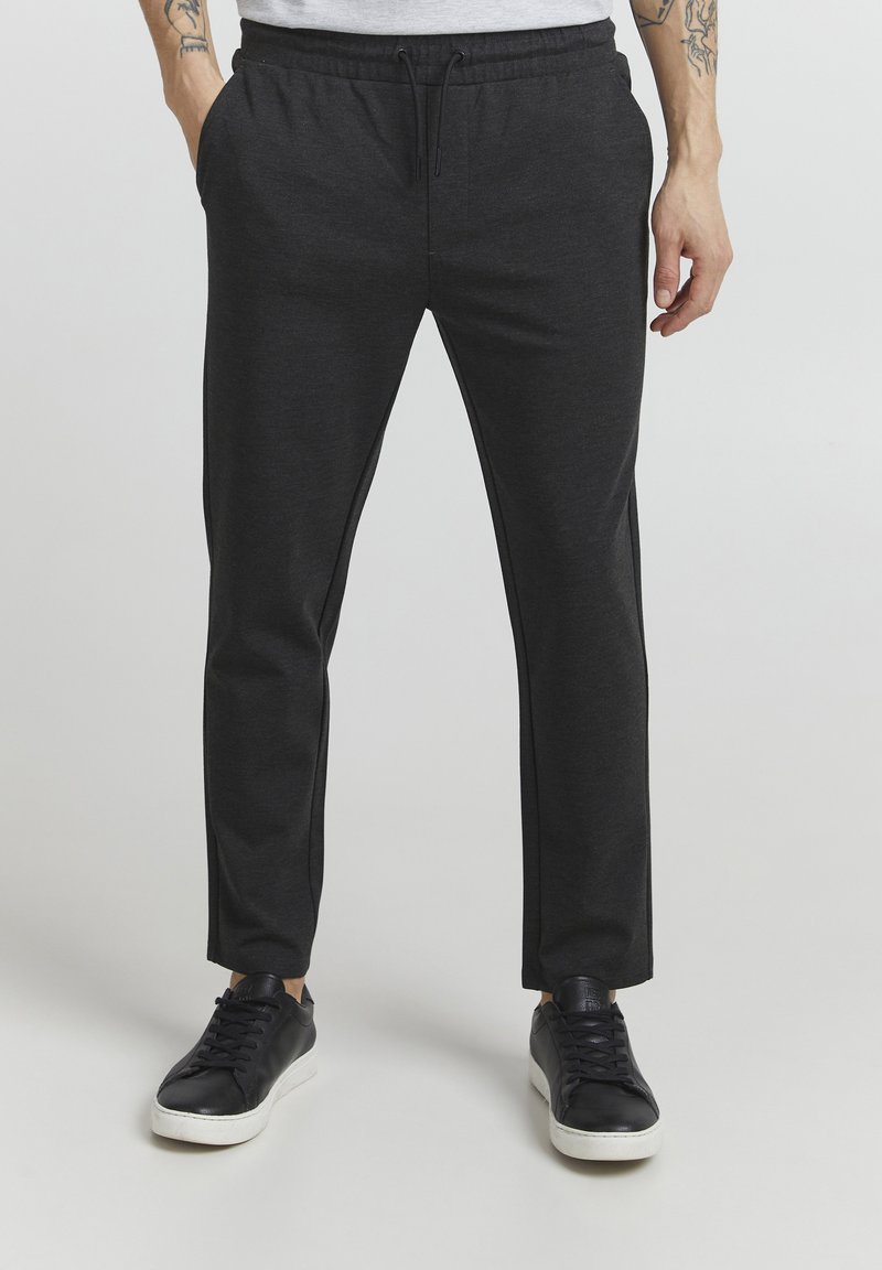 Dark gray, tapered sweatpants with an elastic waistband, drawstring, side pockets, and contrasting side stripes. Cotton blend fabric.