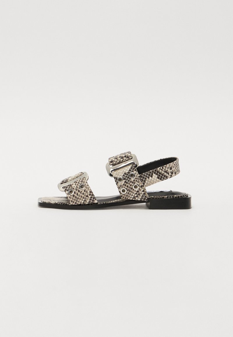 Flat sandals with snake print pattern, silver-tone hardware, two adjustable straps, and a low black sole. Textured upper material.