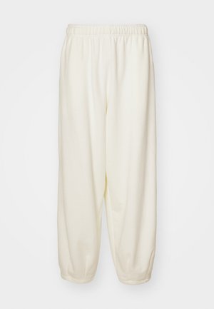 Cream-colored sweatpants made of soft fabric, featuring an elastic waistband and tapered cuffs, with a relaxed fit and no visible patterns.