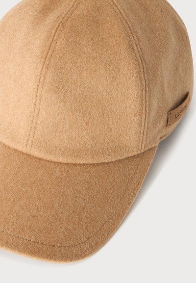 Casquette de baseball en laine brun clair avec coutures visibles et petite étiquette latérale sur fond blanc.