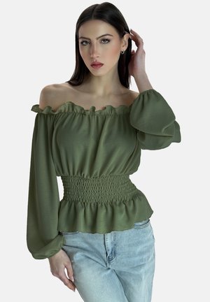 Olivgrünes Off-Shoulder-Bluse mit rüschigen Kanten, gerafftem Bund und langen Ärmeln, aus leichtem Stoff gefertigt. Kombiniert mit hellblauen Jeans.