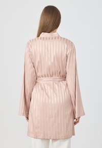Lichtroze satijnen kimono met verticale strepen, lange mouwen, een gestrikt middel en een gladde textuur. Achteraanzicht weergegeven tegen een effen achtergrond.
