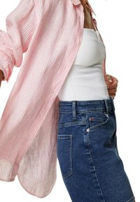 Lichte katoenen shirt, roze en witte gestreept, gedragen open over een aansluitend wit ribbed shirt. Donkerdenim rok met achterzakdetail.