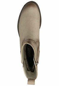 Bottine beige en cuir lisse, avec des panneaux latéraux élastiques, un bout rond et une languette de traction à l'arrière. Intérieur doublé avec une étiquette de marque visible.