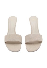 Sandales à enfiler beiges avec de larges brides en tissu, doublure texturée et semelles plates. Fini lisse avec un branding subtil sur la semelle intérieure.