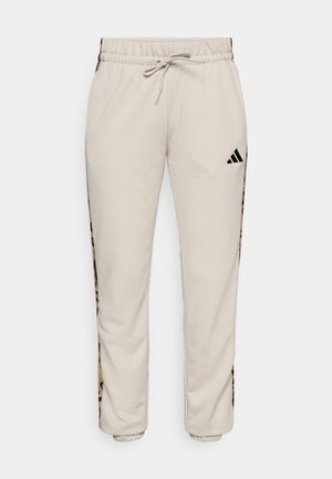 Lichtbeige sweatpants van zacht materiaal, met een trekkoord in de taille en zwarte zijpanelen met een luipaardpatroon.