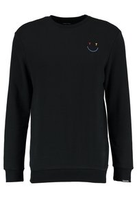 Svart långärmad crewneck-tröja med en liten broderad smiley-ansikte på vänster bröst, med röd "Y", gul "T" och en blå böjd linje.