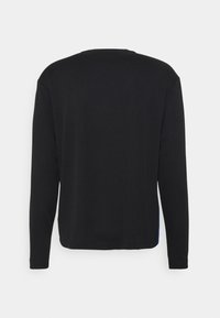 Langärmliges schwarzes Shirt aus weichem Stoff, mit einem schlichten Rundhalsausschnitt und blauen Seitenakzenten am unteren Saum.