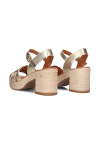 Gouden sandalen met bandjes en een gesloten achterkant, voorzien van een brede blokhak gewikkeld in textuur touw en een tan interieurvoering.