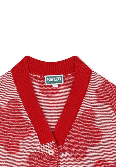 Cardigan rayé rouge et blanc avec un col côtelé, doté d'une fermeture à bouton et d'une texture lisse. Étiquette de marque visible à l'intérieur.