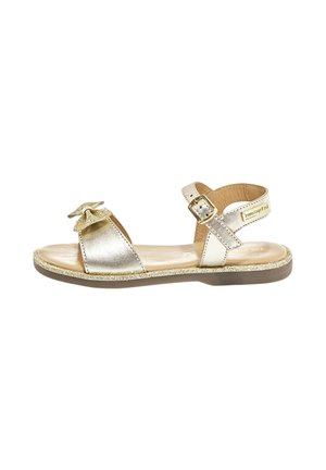 Metallische zilveren sandalen met een strikaccent, verstelbare enkelband en glinsterende zool. Beschikt over een open teens ontwerp en een platte hak.