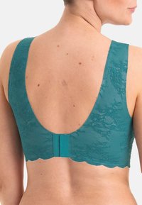 Teal Spitzen-BH mit breiten Trägern, gewellten Kanten und einem tiefen, abgerundeten Rücken. Verfügt über einen glatten Verschluss mit einem strukturierten Blumendesign.
