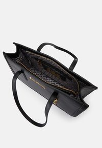 Melnas ādas somiņa ar divām rokturiem, iekšējo rāvējslēdzēja kabatu, zelta furnitūru un auduma oderi ar atkārtotu teksta dizainu.