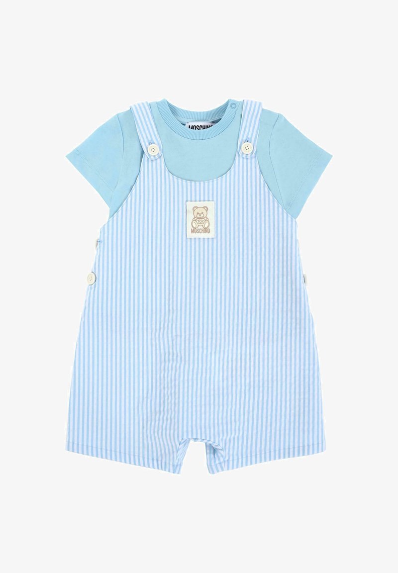 Salopette rayée bleue avec une chemise bleu clair. Caractéristiques : boutons, patch logo ours et jambes courtes. Matière en coton, design décontracté.