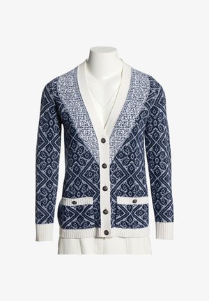 Cardigan tricoté bleu marine et blanc avec des motifs géométriques, boutons sur le devant, deux poches avant et poignets et ourlet côtelés blancs.