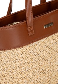 Braune Lederhandtasche mit einem strohähnlichen, geflochtenen Körper, der eine glatte Textur aufweist, und einem Reißverschlussverschluss sowie einem goldenen Logo-Akzent.