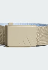 Cinturón tejido beige con una superficie texturizada, que presenta una hebilla de plástico beige mate con un logotipo grabado y un patrón recortado.