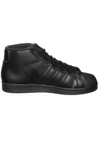 Svart läder hög sneaker med gummisula, texturerad ovandel, rund tå och tre ränder design på sidan. Svarta skosnören.