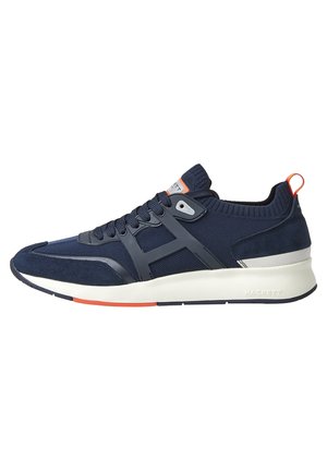 Granatowo-czarne sportowe buty z białą podeszwą, pomarańczowymi akcentami, cholewką z siateczki i zamszu oraz oznaczoną pętlą na pięcie.