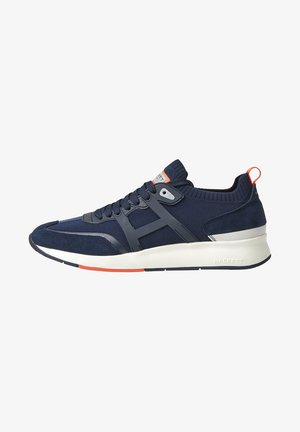 Basket de sport bleu marine et noir avec semelle blanche, accents orange, empeigne en mesh et suède, et languette de talon brandée.