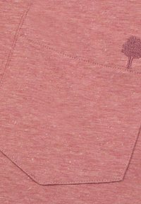 Roze melange stof met een gestructureerd, gemêleerd uiterlijk. Bevat een zak met een gestikte rand en een klein bomenembleem in een donkerdere tint.