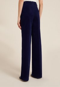 Marineblauwe corduroy wijde broek met een zachte textuur, hoge taille en zijzakken, voorzien van verticale ribbels voor extra detail.