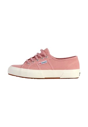Light pink canvas sneaker with white rubber sole, round toe, six silver eyelets, and a rectangular logo tag on the side.