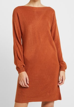 Robe en maille à manches longues de couleur rouille riche. Dotée d'un large col bateau et de poignets élastiques, créant une silhouette décontractée.
